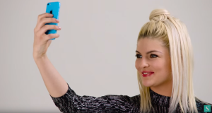 Model met blond haar in grafische jurk maakt selfie Stylight